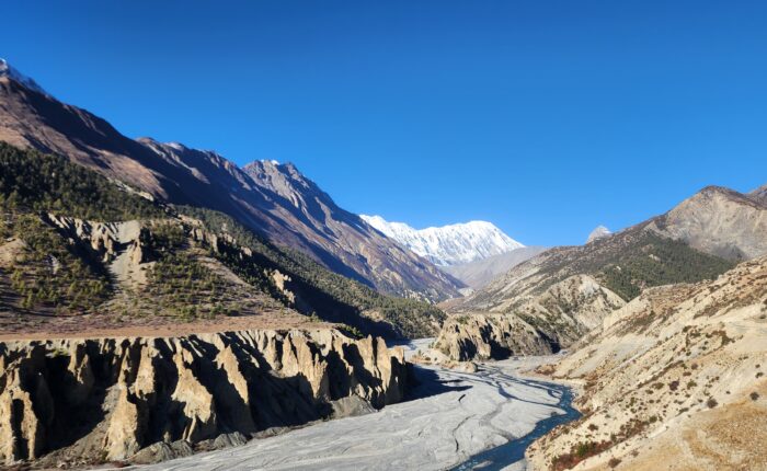 The Annapurna Circuit trekking trail showcases steep mountains, alpine scenery, and courageous hikers.