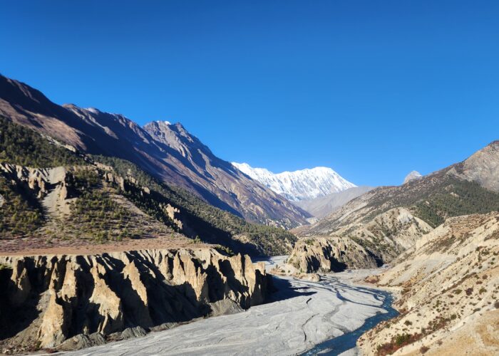 The Annapurna Circuit trekking trail showcases steep mountains, alpine scenery, and courageous hikers.